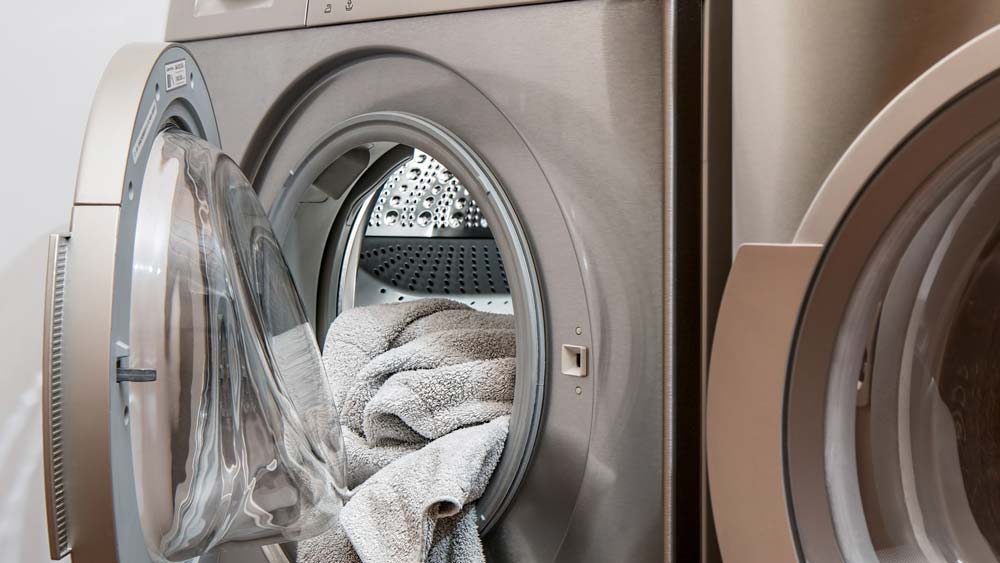 A dryer. The door is open and it is full of fresh laundry